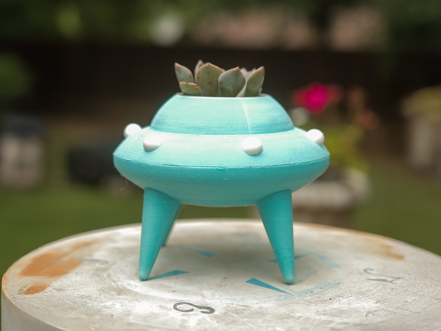 glow in the dark UFO-shaped planter with a succulent.